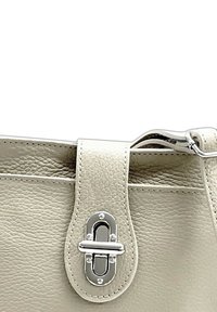Lichtgrijze leren handtas met een gestructureerd oppervlak, voorzien van een elegante zilveren sluiting en stikdetails langs de randen.