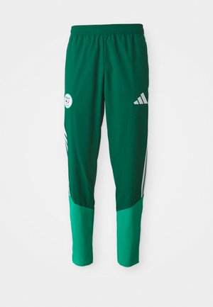 Zaļas sporta bikses ar gaiši zaļiem apakšējiem posmiem, elastīgs jostasvieds, balts Adidas logo labajā augšstilbā un sporta emblēma kreisajā augšstilbā.