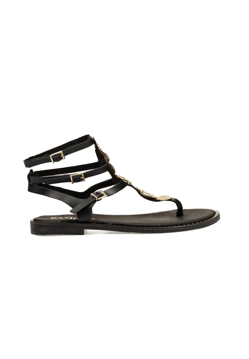 Sandalias planas negras con múltiples tiras delgadas y acentos dorados. Presentan un diseño de tira en forma de T y hebillas ajustables en las correas del tobillo.