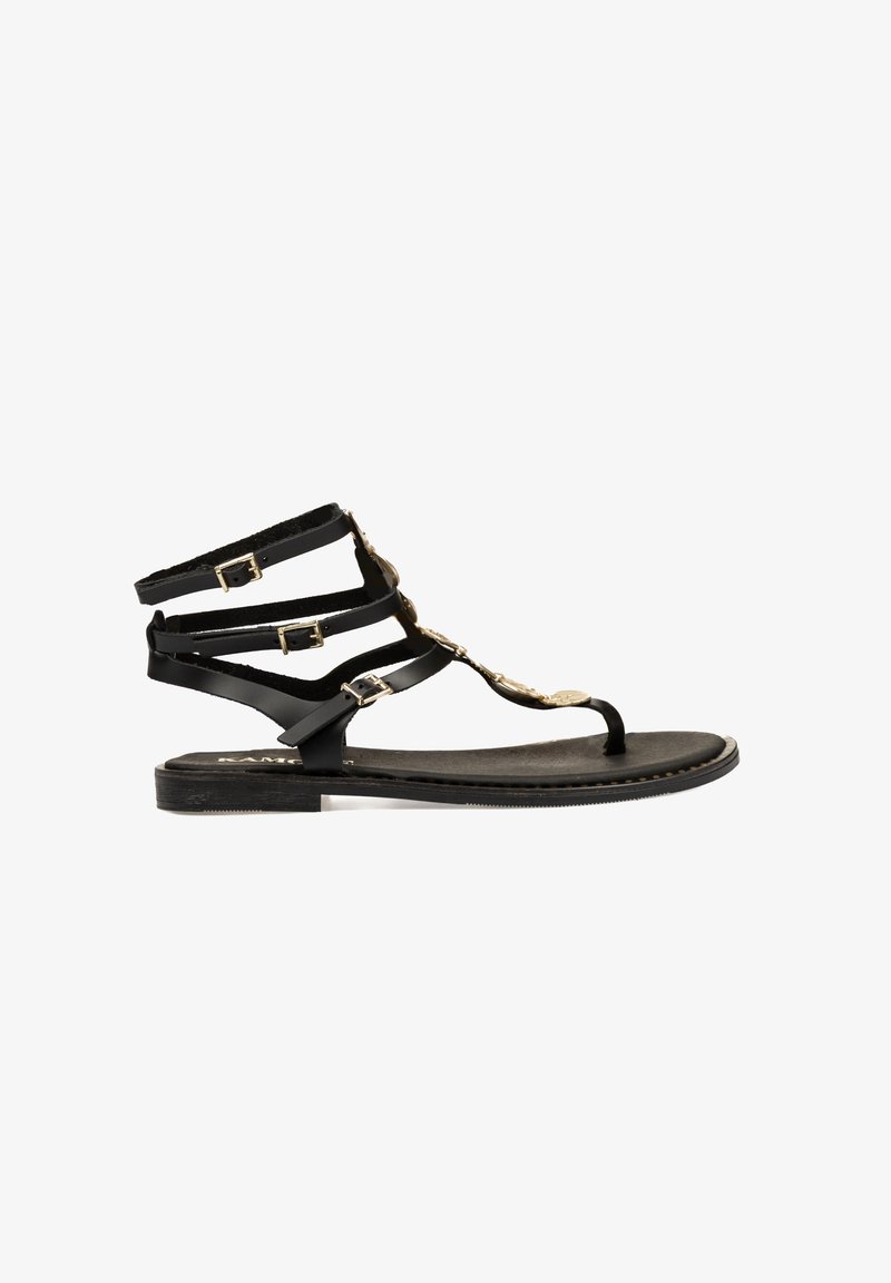Sandalias planas negras con múltiples tiras delgadas y acentos dorados. Presentan un diseño de tira en forma de T y hebillas ajustables en las correas del tobillo.