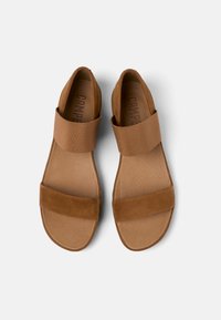 Bruna sandaler med ett framrem i mocka och ett strukturerat elastiskt band. Slätt innersula och en något konturerad yttersula. Platt design.