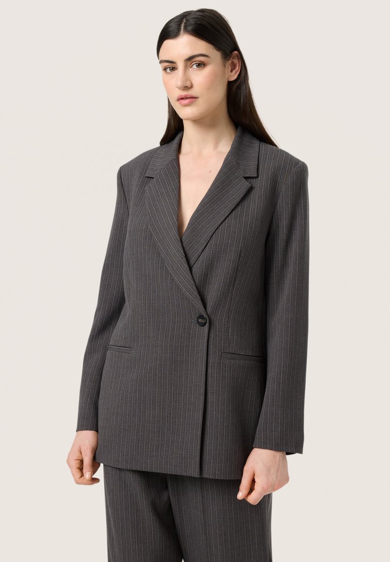 Grå rillede dobbeltradede blazer med en notch lapel, lange ærmer og forlommer, fremstillet af et glat stof.