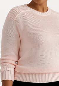 Světle růžový pletený svetr s texturovaným designem na ramenou, hřejivými manžetami a kulatým výstřihem, s volnějším střihem a prodyšným materiálem.