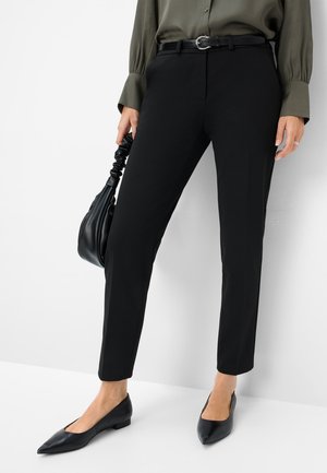 Black tailored trousers with a slim fit, smooth fabric, belt with a silver buckle, paired with black pointed-toe flats and a black handbag.