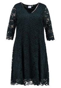 Robe noire mi-longue avec superposition de dentelle florale, encolure en V et manches trois-quarts en dentelle transparente.