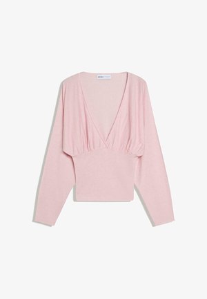 Világos rózsaszín hosszú ujjú felső mély V-nyakkivágással és a mell alatt összegyűrt anyagrésszel, amely karcsúsított derékvonalat formáz.