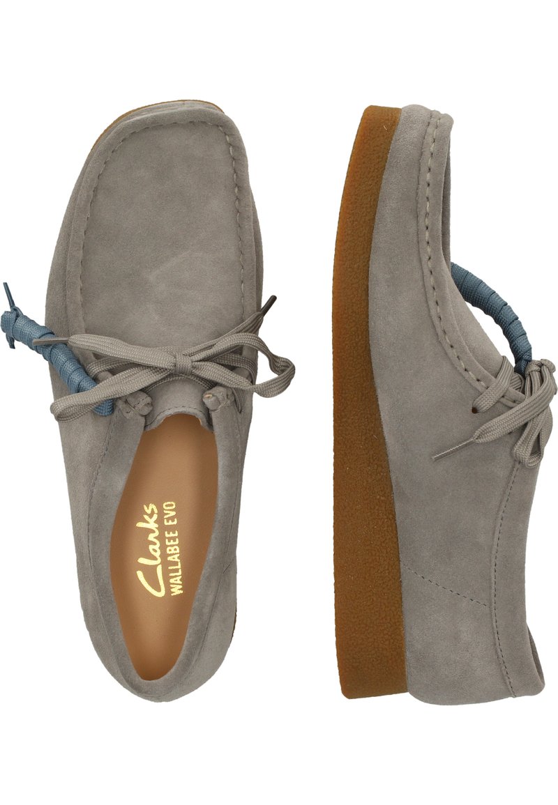 Zapatos Clarks Wallabee Evo en ante gris con acentos de cordones azules. Punta redonda, cuello acolchado, suela de goma con acabado texturizado.