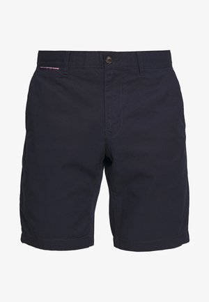 Navy blue cotton shorts with a button closure, neatly stitched hem, and a small red, white, and blue accent on the waistband.