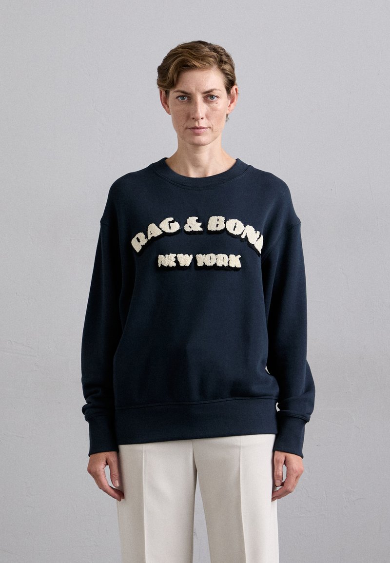 Navy bluza z teksturowanym kremowym napisem "RAG & BONE NEW YORK." Posiada okrągły dekolt i prążkowane mankiety. Miękka tkanina.
