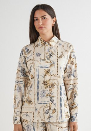 Chemise à boutons à motif floral beige clair, ornée d'accents bleus et marron, avec un col classique et des manches longues.