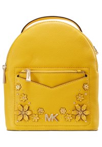 Mochila de cuero amarillo con forma redondeada. Presenta embellishments florales, herrajes dorados, un bolsillo con cremallera en la parte frontal y un logo en relieve.