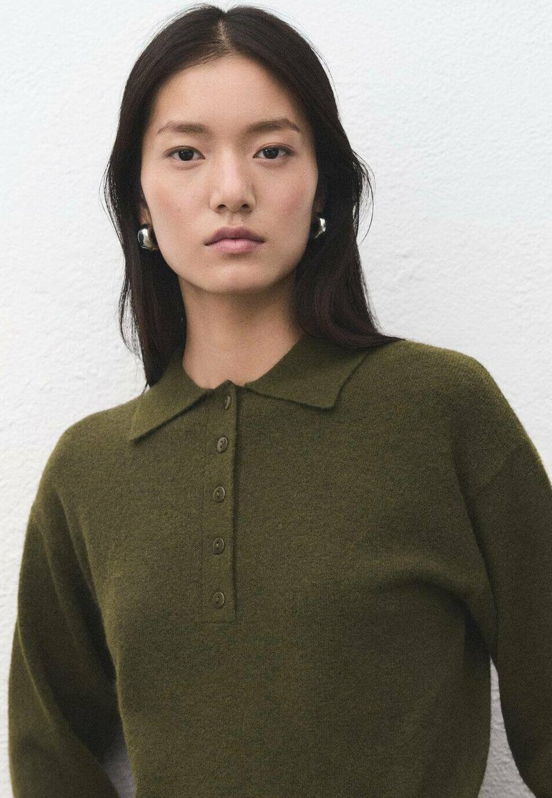 Suéter de punto verde oliva con diseño de cuello, que presenta una tapeta con botones y tejido texturizado. Corte suave y relajado con mangas largas.