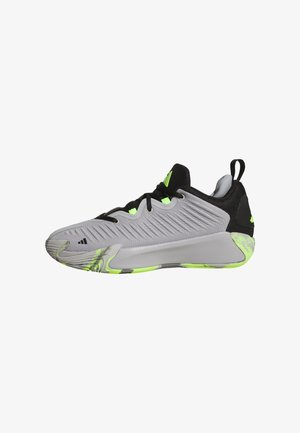 Chaussure de sport grise avec une tige texturée, des accents noirs et des détails verts vifs. Elle dispose d'un col rembourré et d'un système de laçage.