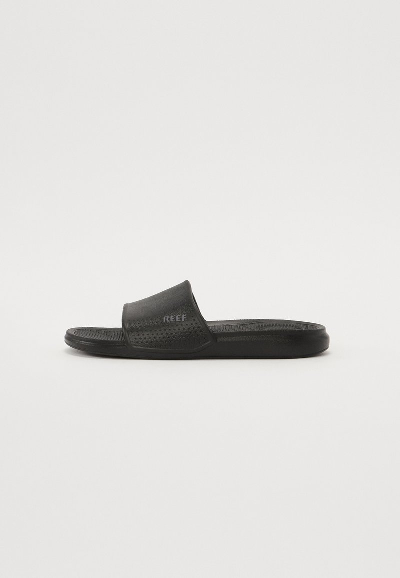 Black slide sandals made of synthetic material with a textured strap and perforated design for breathability, featuring a raised logo on the side.