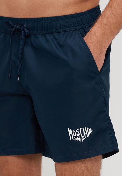 Shorts de baie bleu marin, realizate dintr-un material ușor, având un tiv elastic cu șnur și un logo alb "Moschino Swim".