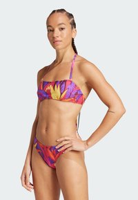Set di bikini multicolore con motivi floreali in rosa, viola e giallo. Il top presenta spalline sottili e un design a banda, con un slip a vita bassa.