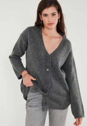Cardigan grigio lavorato a maglia con scollatura profonda a V, chiusura a bottoni e maniche lunghe. Texture morbida e dettagli a coste su polsini e orlo.