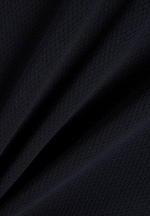 Tumši zils teksturēts audums ar smalkām vertikālām malu līnijām un mīkstām locījumiem, kas rada ēnainas līnijas un dziļumu.