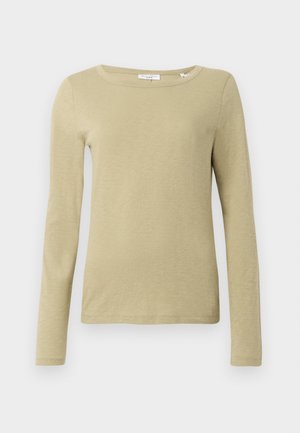 Chemise à manches longues de couleur olive clair, faite d'un tissu doux avec une texture lisse. Elle possède un large décolleté et une silhouette ajustée.
