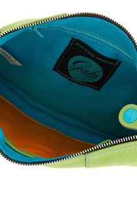 Portafoglio con zip in pelle verde, con interno in tessuto turchese e arancione, dotato di etichetta con logo e una piccola chiusura a pressione blu.