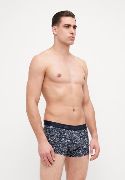 Caleçons boxers bleu marine avec un motif texturé, dotés d'une taille sombre arborant le logo "EMPORIO ARMANI" en argent.