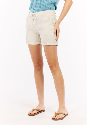 Shorts beige clair avec une taille à cordon, des revers roulés et des poches latérales. Le matériau est un coton lisse avec une coupe décontractée.