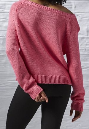 Suéter rosa de punto, suelto y con hombros descubiertos, que cuenta con puños y dobladillo acanalados; combinado con leggings negros que muestran un acabado de tela texturizada.