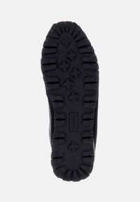 Suola di sneaker in gomma nera con un profondo motivo di battistrada, caratterizzata da forme esagonali e a croce per una maggiore aderenza. Il materiale sembra durevole con bordi rinforzati.