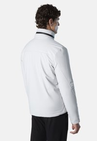 Weiße Jacke mit hohem Kragen und schwarzen Akzenten. Verfügt über eine glatte Textur und dezentes Branding auf der Rückseite. Maßgeschneiderte Passform.