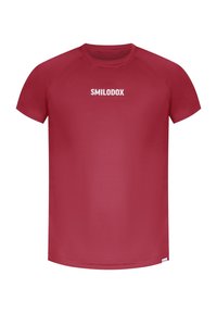 Röd sportt-shirt tillverkad av slät tyg. Har rund hals och korta ärmar. "SMILODOX"-logotypen tryckt i vitt över bröstet.