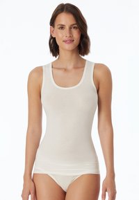 Top in beige chiaro senza maniche con scollatura amoidale e spalline larghe. Realizzato in un tessuto morbido e liscio, presenta un design aderente che si adatta al corpo.