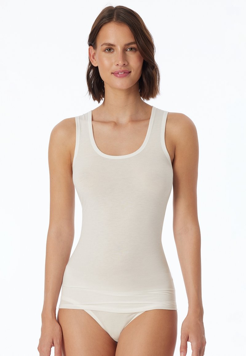 Top in beige chiaro senza maniche con scollatura amoidale e spalline larghe. Realizzato in un tessuto morbido e liscio, presenta un design aderente che si adatta al corpo.