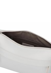 Weißes Lederhandtasche mit glatter Textur, ausgestattet mit einem Reißverschluss oben und einem braun gefütterten Innenraum mit zusätzlicher Reißverschlusstasche.