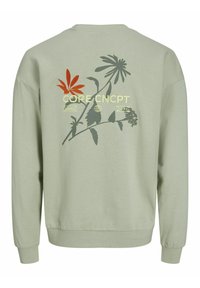 Sweat-shirt vert clair à manches longues avec un motif floral et le texte "CORE CNCPT" dans le dos.