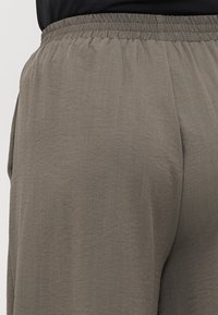 Γκρίζα, ελαφριά, φαρδιά παντελόνια με ελαστική μέση και υφή υφάσματος. Διαθέτουν πλαϊνές τσέπες και απαλή πτώση.