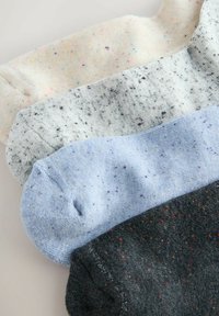 Gemischtes Set aus vier Socken: cremefarben mit bunten Sprenkeln, grau mit schwarzen Sprenkeln, hellblau mit lila Sprenkeln und dunkelgrau mit roten Sprenkeln.