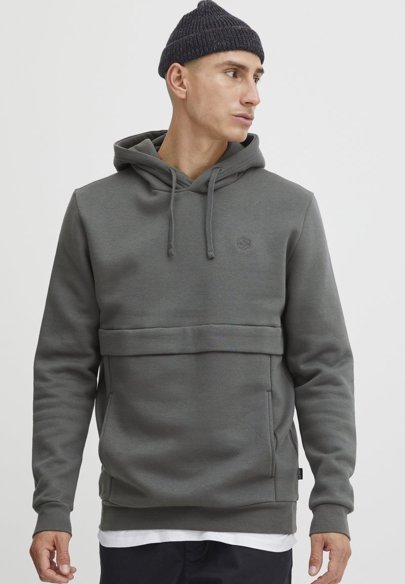 Gray hooded sweatshirt with a front pocket, a textured fabric, and subtle branding. It has a relaxed fit and adjustable drawstrings.