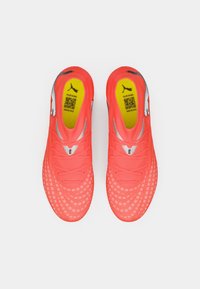 Zapatillas deportivas de color rosa brillante con una parte superior texturizada, suela exterior con patrón, detalles en gris y plantilla amarilla con un código QR.