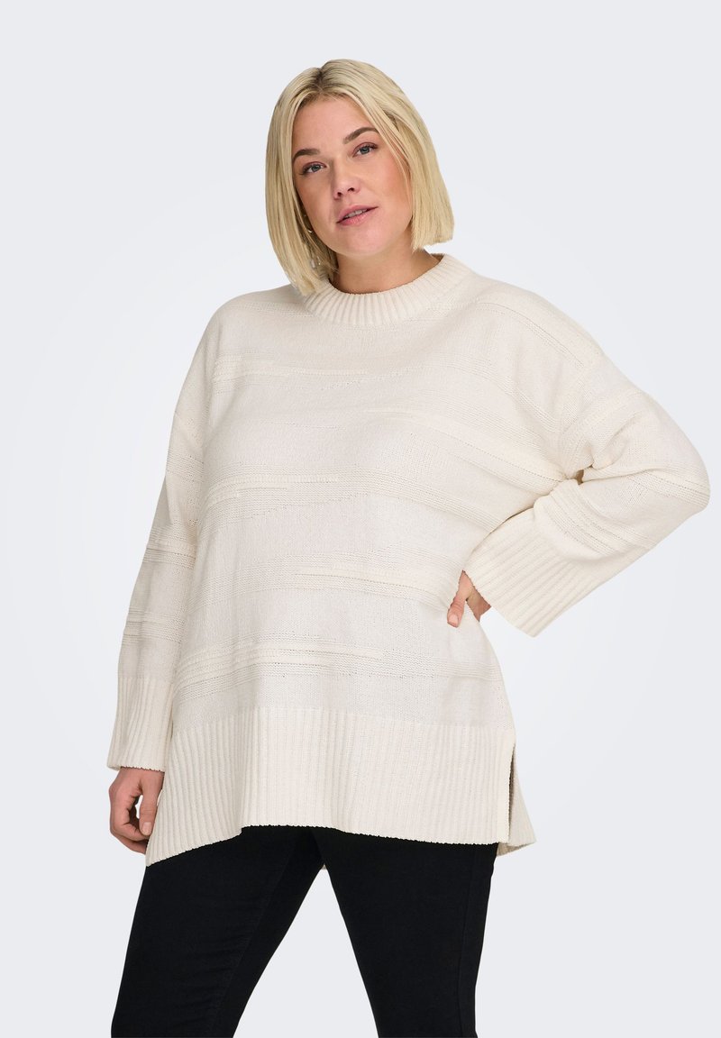 Pull en maille couleur crème avec un col rond côtelé, des manches longues et des fentes latérales ; présente des motifs texturés horizontaux subtils.