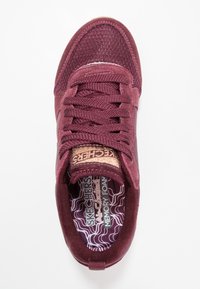 Burgundy sneaker with mesh and suede upper, padded collar, round laces, and cushioned memory foam insole with wave pattern.