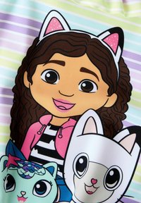 Cartoonontwerp met een meisje met krullend haar en een haarband met kattenoren, geflankeerd door een blauwe kat en een witte kat met roze accenten. Gestreepte achtergrond.