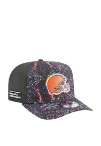 Schwarze Kappe mit einem Spritzlack-Design in Pink, Blau und Gelb. Mit einem Cleveland Browns-Logo und einem "Crucial Catch"-Tag an der Seite.