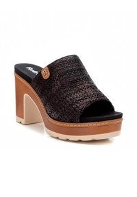 Sandalia deslizante negra de tejido con tacón bloque y plataforma. Presenta un acento en tono marrón y una plantilla negra. Detalle de costura alrededor de la suela.