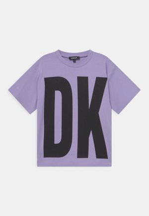 T-shirt lavande à manches courtes avec de grandes lettres noires "DK" sur le devant et une petite étiquette DKNY à l'intérieur du col.