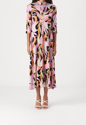 Dlouhé šaty s knoflíky, dlouhými rukávy, v růžovém, černém a oranžovém květinovém vzoru. Lehká látka s midi délkou, doplněné bílými sandálkami na podpatku s pásky.