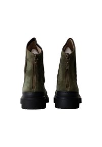 Stivali ankle in suede verde con suole in gomma nere, dotati di una cerniera dorata sul retro e una fodera interna liscia.