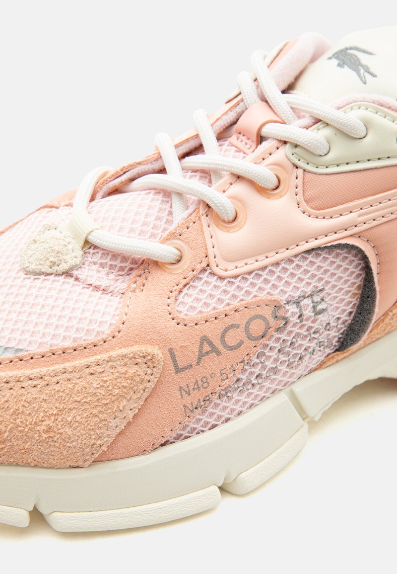 Scarpa da ginnastica Lacoste rosa e beige con lacci bianchi, texture in mesh e suede, coordinate stampate e logo del coccodrillo brandizzato sulla linguetta.