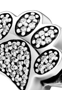 Anello in argento con cinque forme ovali incastonate con piccoli cristalli trasparenti rotondi su uno sfondo nero, che mette in risalto una finitura lucida.