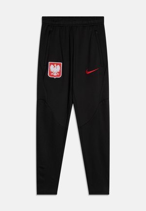 Schwarze Sporthosen aus Polyester. Mit Reißverschlusstaschen, einem gestickten polnischen Emblem am linken Bein und einem roten Nike-Logo auf der rechten Seite.