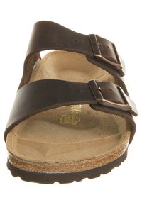 Brun læder sandal med to justerbare stropper og sølv spænder, der har en formet ruskindsfodbed og en tekstureret gummisål.